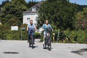 two people riding their bikes down a street at The Little Guesthouse in Salzburg