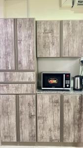 a microwave sitting on top of a counter in a kitchen at Alsayah in Jazīrat as Sāyah