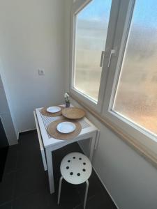 a small table with a chair and a window at Quarto 15 min de Lisboa in Amadora