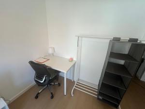 an office with a desk and a chair and a book shelf at Quarto 15 min de Lisboa in Amadora +14 photos