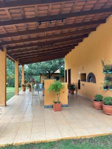 an outdoor patio with a wooden ceiling and potted plants at Chácara porta do sol in Mairinque