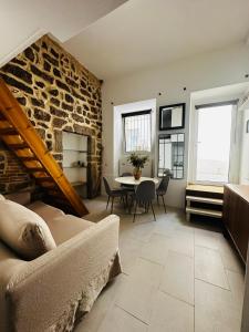 a living room with a table and a stone wall at Victoria in Olbia