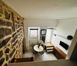 a living room with a table and a stone wall at Victoria in Olbia