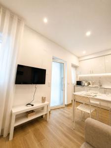 a living room with a table and a television on a wall at Casa Rabiosa in Nazaré