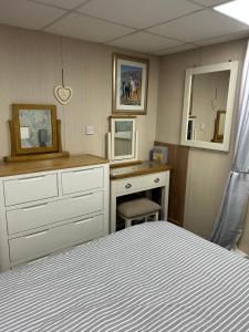 a bedroom with a bed and a desk and a mirror at Cleethorpes beach haven site in Cleethorpes