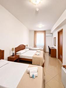 a hotel room with two beds and a desk at Hotel Futuro in Aversa +29 photos