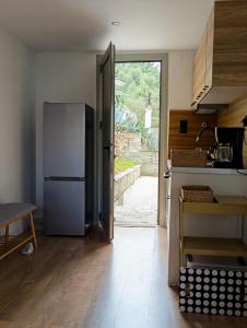 a kitchen with a refrigerator and an open door at Agave by Aloe Residence Possidi in Possidi
