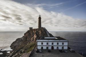 a lighthouse on a cliff next to the ocean at Apartamento familiar acogedor in Ordes
