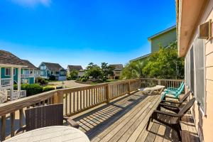a deck with chairs and tables and houses at 6165 - Fantasy Land in Kill Devil Hills