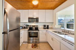 a kitchen with white cabinets and a stainless steel refrigerator at 6165 - Fantasy Land in Kill Devil Hills