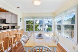 a kitchen and dining room with a wooden table and chairs at 6165 - Fantasy Land in Kill Devil Hills
