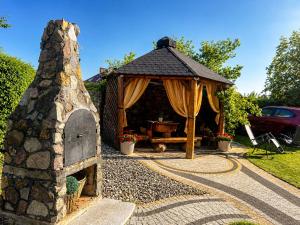 a gazebo with a tent and a stone fireplace at Willa Kapitańska i Willa Marynarska in Łeba