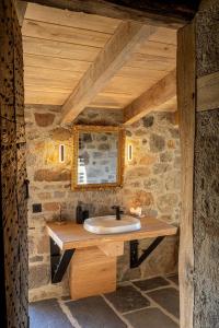 a bathroom with a sink in a stone wall at Buron du Tournel, un écrin d'exception in Le Lioran