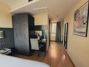 a hotel room with a desk in a room at Hotel Faranda Pathos Gijón, Ascend Hotel Collection in Gijón