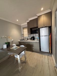 a kitchen with a table and a refrigerator at Sharwood Place in Port Elizabeth +13 photos