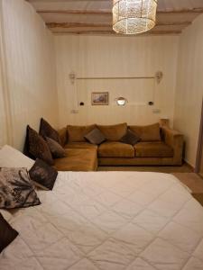 a living room with a large bed and a couch at Gîte berbère in Tagadirt Alkadi