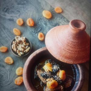 a bowl of soup next to a pot of food at Gîte berbère in Tagadirt Alkadi