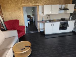 Eine Küche und ein Wohnzimmer mit weißen Schränken und einem roten Sofa in der Unterkunft imperial 3 in Leuenberg + 6 Fotos