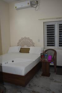 a bedroom with a bed and a table and a window at Hotel KGR in Palni