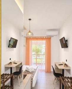 a living room with a bed and a table and chairs at H Stella Apartments & Rooms in Kalamitsi