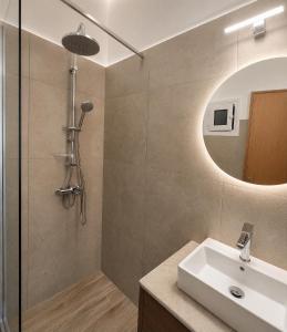 a bathroom with a sink and a shower with a mirror at H Stella Apartments & Rooms in Kalamitsi +51 photos