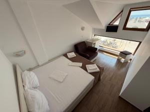 a small bedroom with a bed and a chair at Complex Turistic Perla Venusului in Venus +26 photos