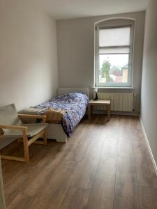 a bedroom with a bed and a window and a wooden floor at Arnold Apartments in Glauchau +19 photos