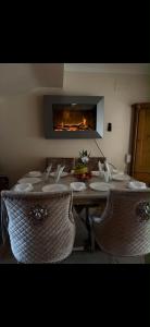 a dining room table with chairs and a fireplace at Dolly's Homestay in Galway