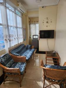 a room with three beds and chairs and a tv at Happy Lodge in Sakumona