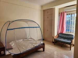 a bedroom with a canopy bed and a chair at Happy Lodge in Sakumona