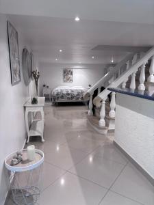 a white room with a bed and a staircase at Appartement Carreira in LʼIsle-Adam +4 photos