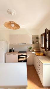 a kitchen with white cabinets and a ceiling at Casa SanGiorgio Stone Villas with Sea View in Skaltsotiánika