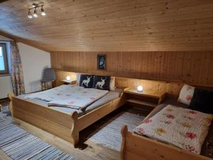 a bedroom with two beds in a log cabin at Ferienwohnungen Zinzlerbauer in Uttendorf