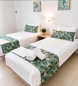 a hotel room with two beds with towels on them at H Stella Apartments & Rooms in Kalamitsi