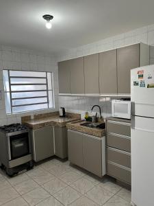 a kitchen with a sink and a stove and a refrigerator at casa top proximo Fenac NH in Novo Hamburgo