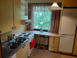 a kitchen with a sink and a stove and a window at Guest room in Retro House in Turku