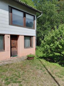 a house with a door and a plant in the yard at Guest room in Retro House in Turku
