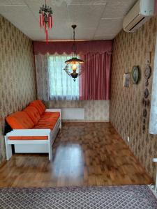 a living room with a couch and a chandelier at Guest room in Retro House in Turku