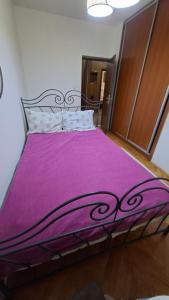 a bed with a purple bedspread on it in a room at Natalia Rooms Old Town in Herceg-Novi
