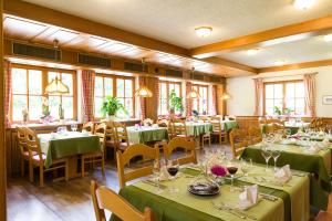 a dining room with green tables and chairs at Landgasthof Kinzigstrand in Biberach bei Offenburg