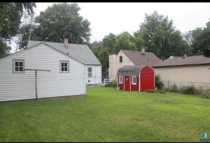 a yard with two houses and a red shed at Serenity Landing in Sioux Falls