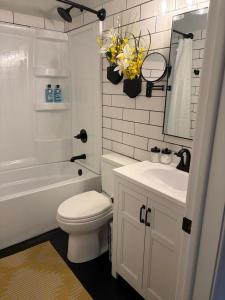 a bathroom with a white toilet and a sink and a tub at Serenity Landing in Sioux Falls +14 photos