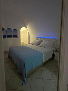 a bedroom with a large white bed with a blue light at 2Steps Capri - central holiday house in Capri +11 photos