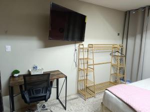 a room with a desk and a television on a wall at Jayua Suites & Habitaciones in Córdoba