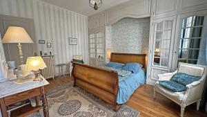 a bedroom with a bed and a chair at La terrasse in Limoges