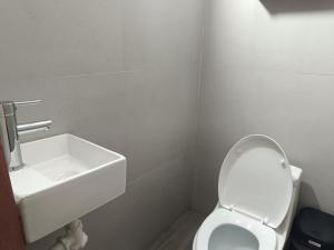 a white bathroom with a sink and a toilet at Jayua Suites & Habitaciones in Córdoba