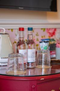 three bottles and glasses sitting on top of a counter at The Market Tavern in Bampton