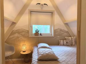 a attic room with a bed under a window at Wonderwild C79, Dog Friendly in Lanaken