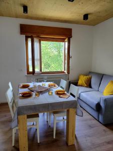 a living room with a table and a couch at Casa Silva in Pieve Tesino