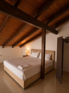 a bedroom with a large bed with wooden ceilings at SkyVista Villa in Iraklitsa